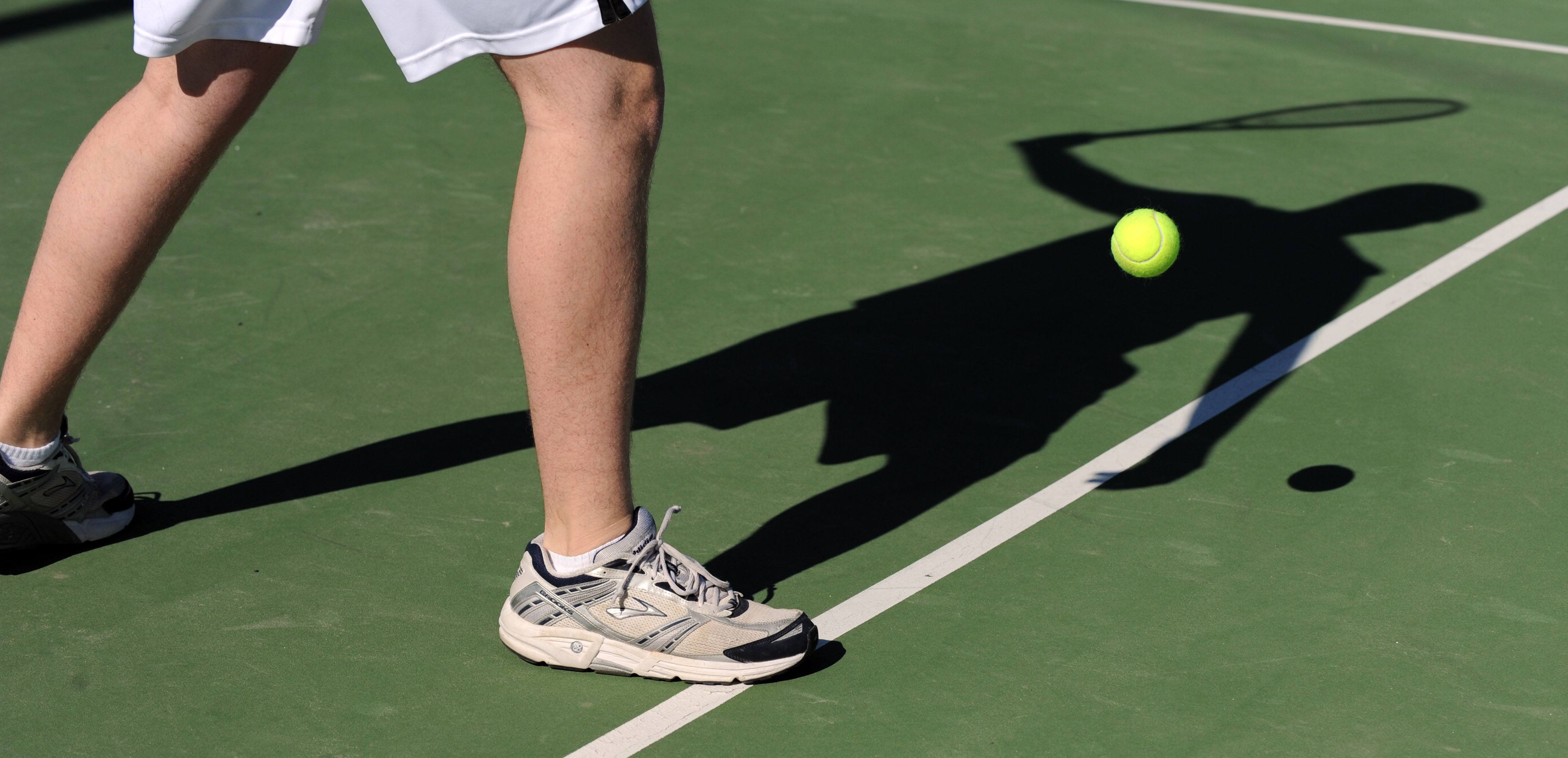 Tennispielerbeine auf dem Platz