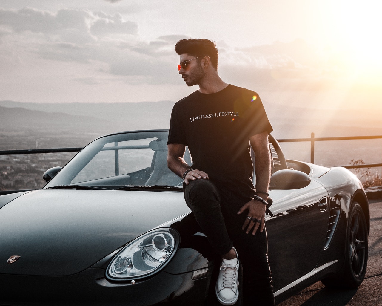 Instagram Influencer mit Auto vor Sonnenuntergang