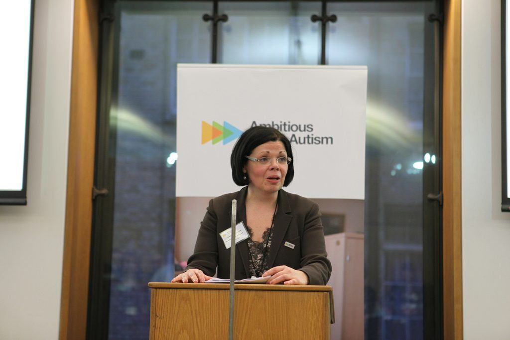 A woman talking at an event surrounding autism