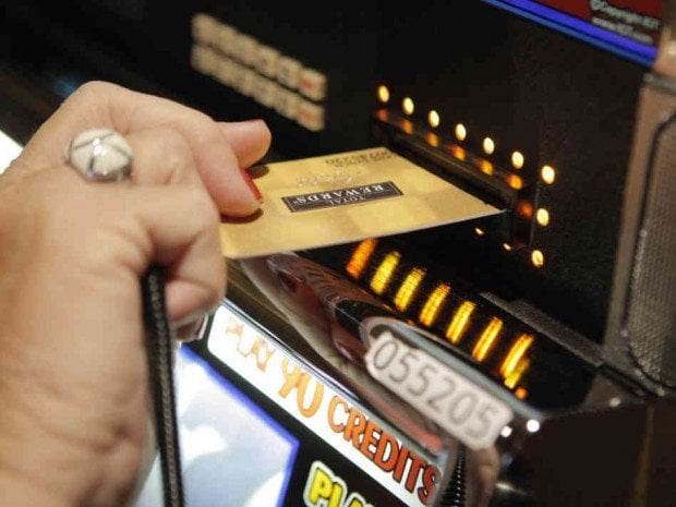 Someone depositing funds with their credit card at a slot machine