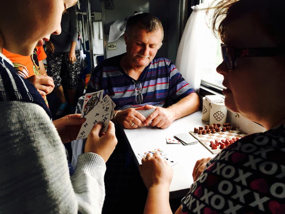 An image of three people playing Durak on a train