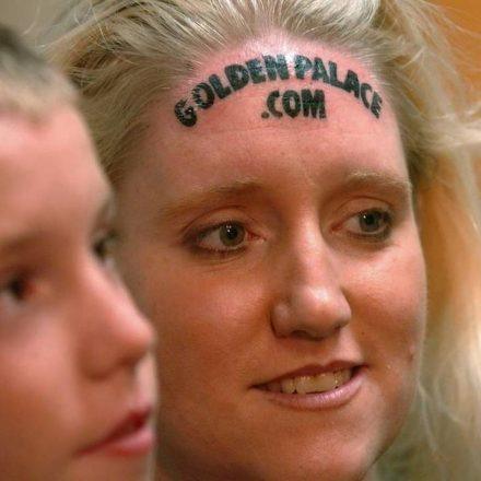 Women's GoldenPalace.com forehead tattoo