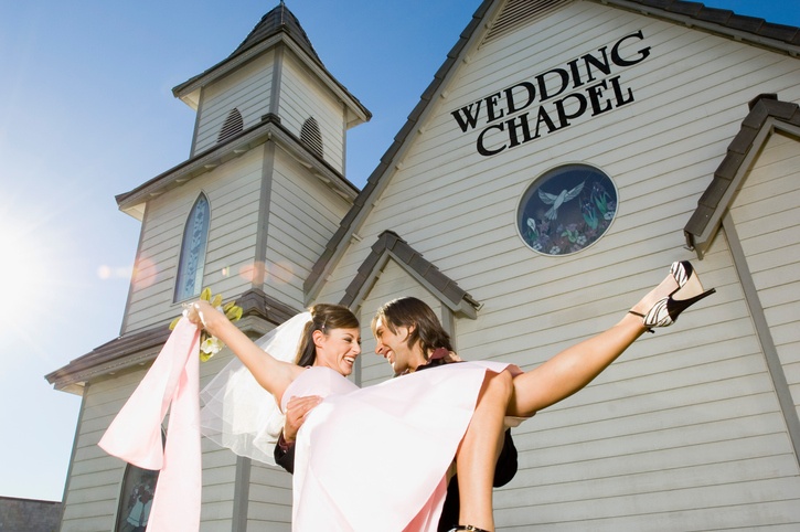Groom carrying bride out of chapel