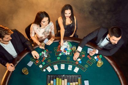 Poker players sitting around a table at a casino.