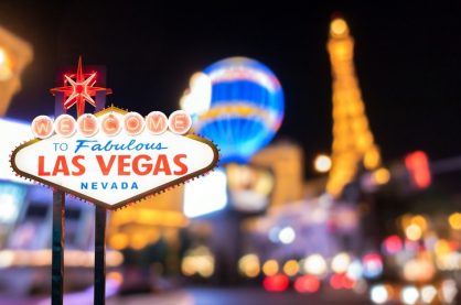 Famous Las Vegas sign at night with Las Vegas Cityscape blur background.