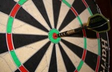 A dartboard with an arrow in the bullseye