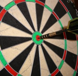 A dartboard with an arrow in the bullseye