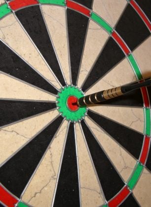 A dartboard with an arrow in the bullseye