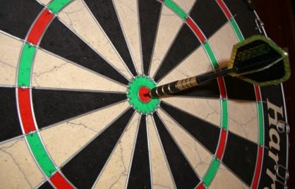 A dartboard with an arrow in the bullseye