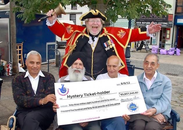 Local people posing with the largest unclaimed Euro Millions jackpot