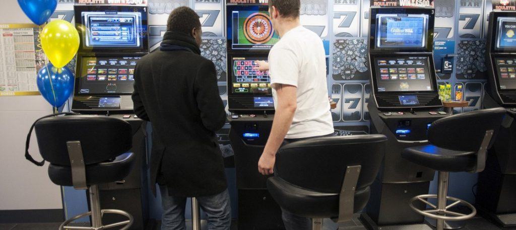 People playing the roulette machine at a bookmakers