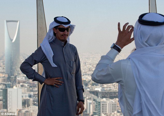 tourists in Saudi Arabia take photos at city attractions