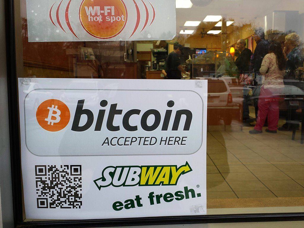 A sign promoting the use of Bitcoin in a market leading fast food store