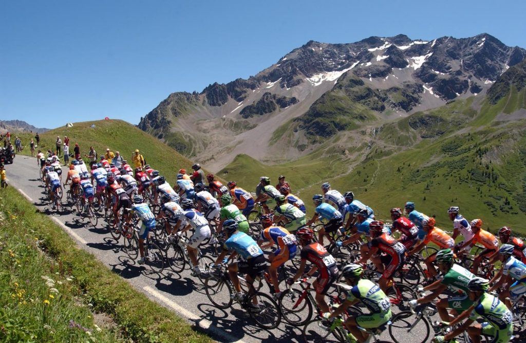 cyclists race past mountains in france