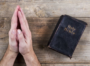 praying hands next to black bible