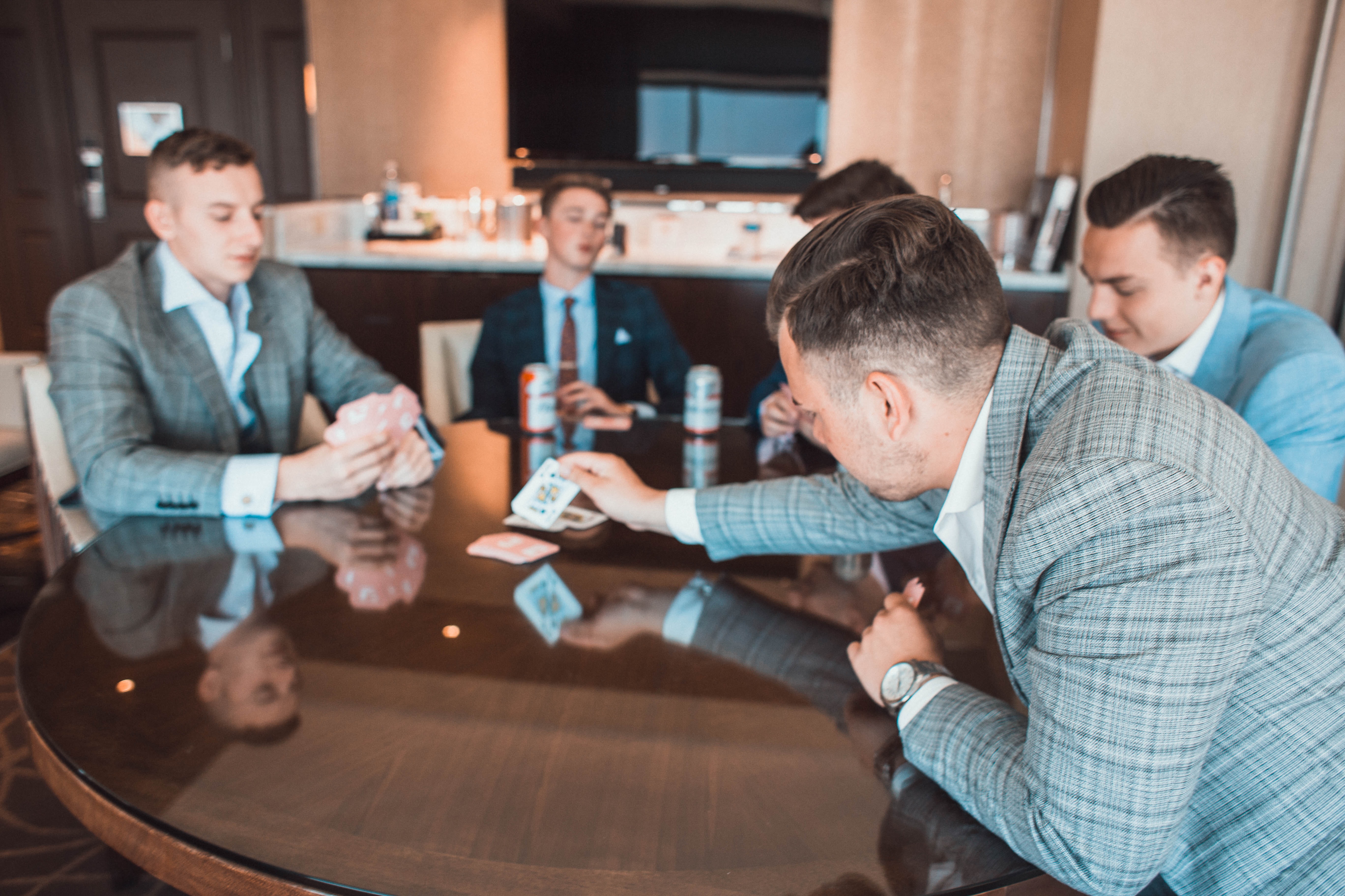 Men playing cards in gray suits. 