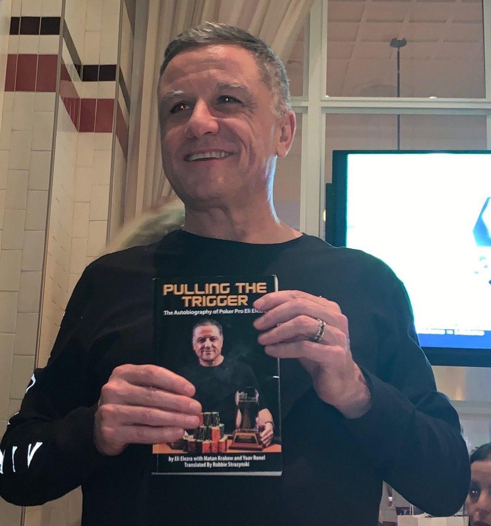 Elezra holding a copy of "Pulling The Trigger"