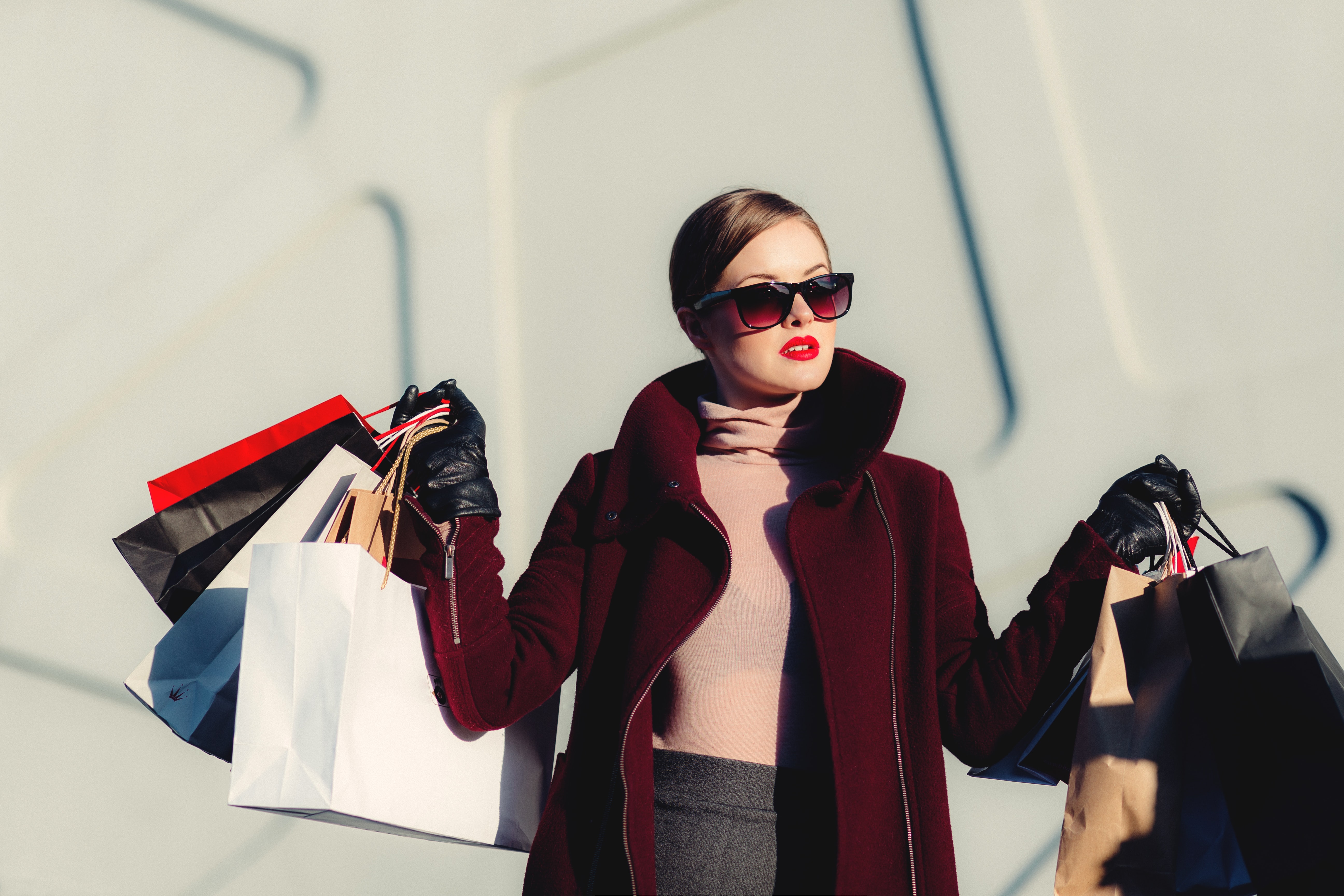 Woman holding white and black paper shopping bags.