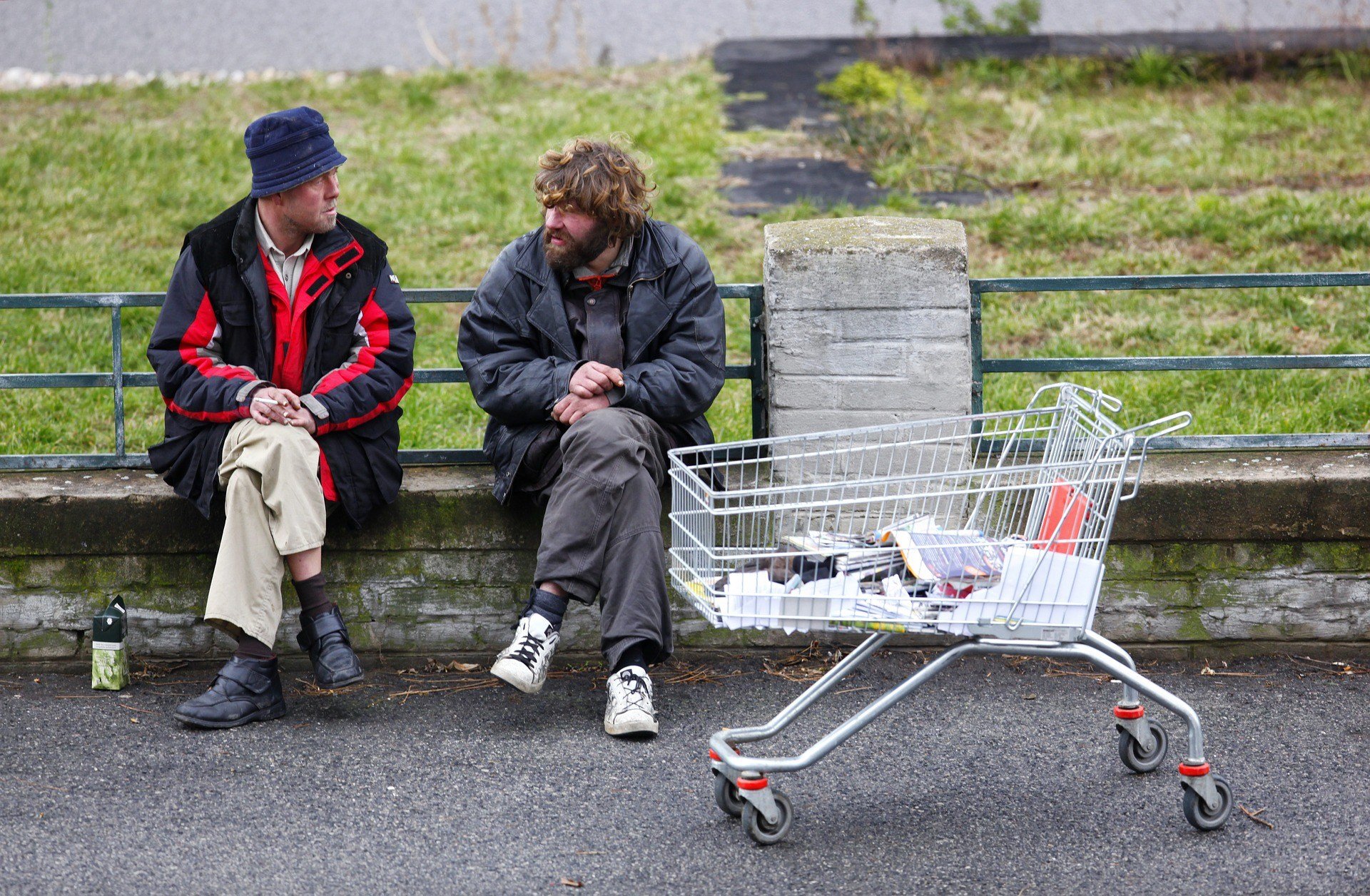 Two homeless men talking and smoking.