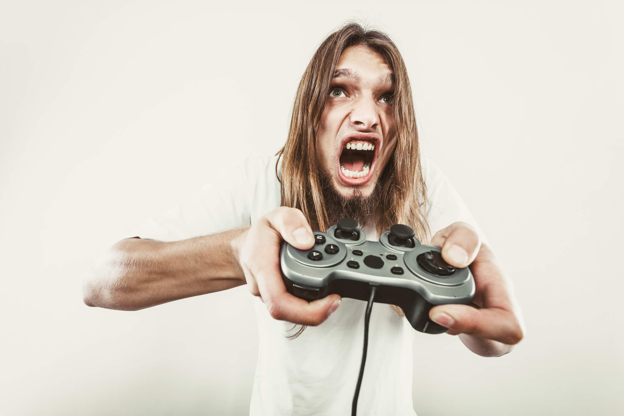 man looking angry while holding game controller