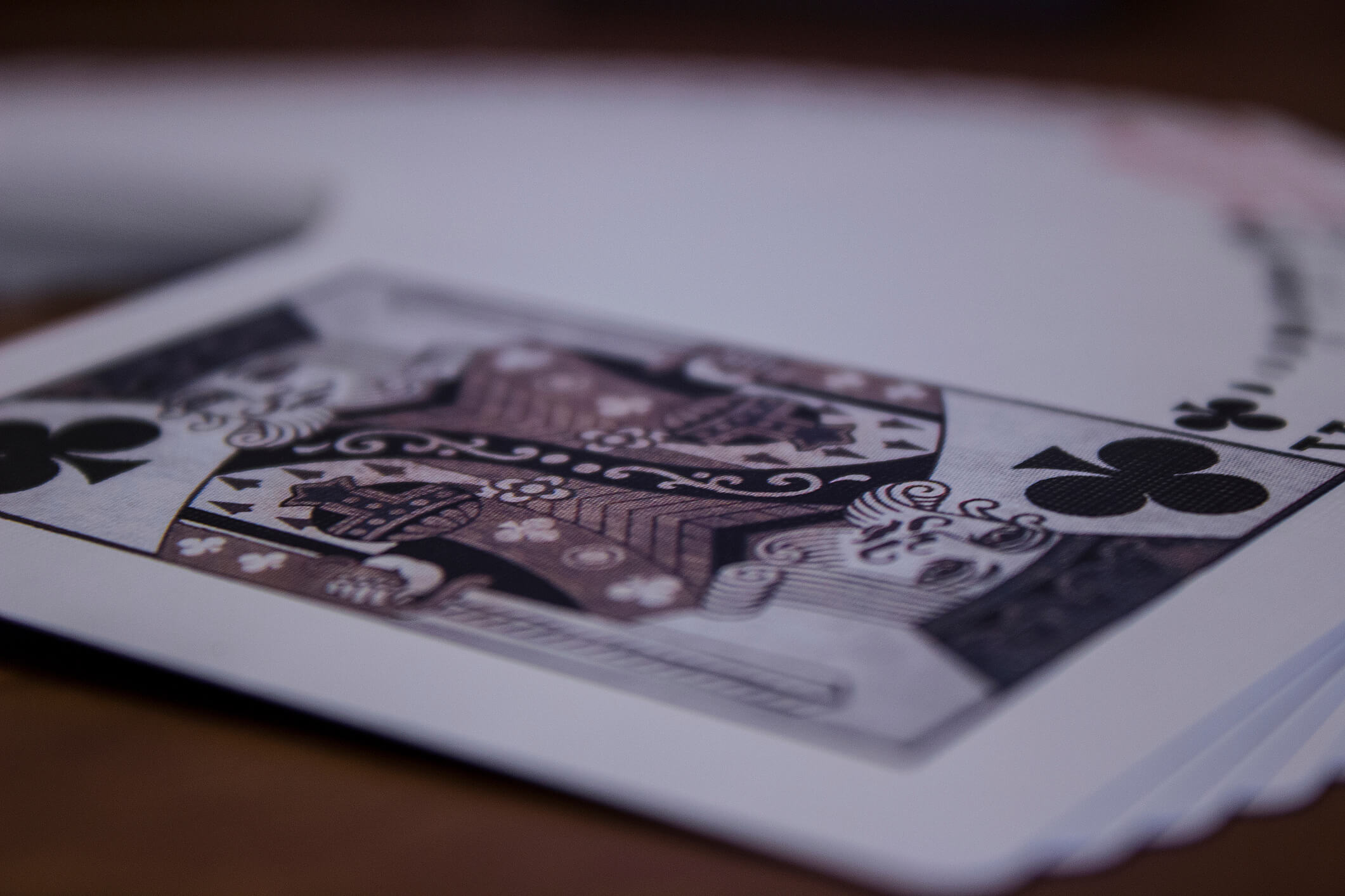 black and white photo of playing cards spread out on blackjack table