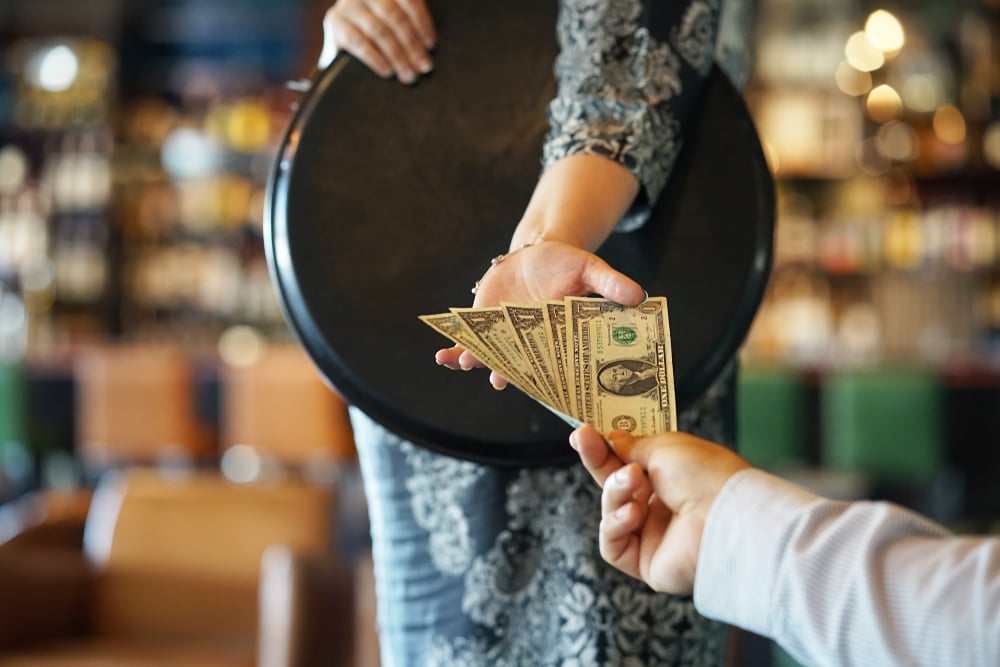 a waiter receiving a tip 