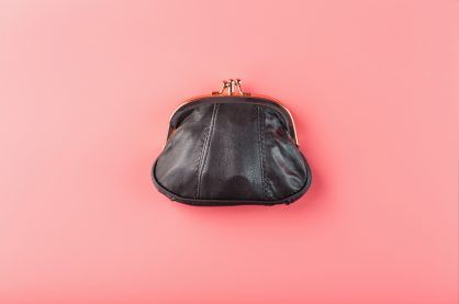 Classic black wallet on a pink background.