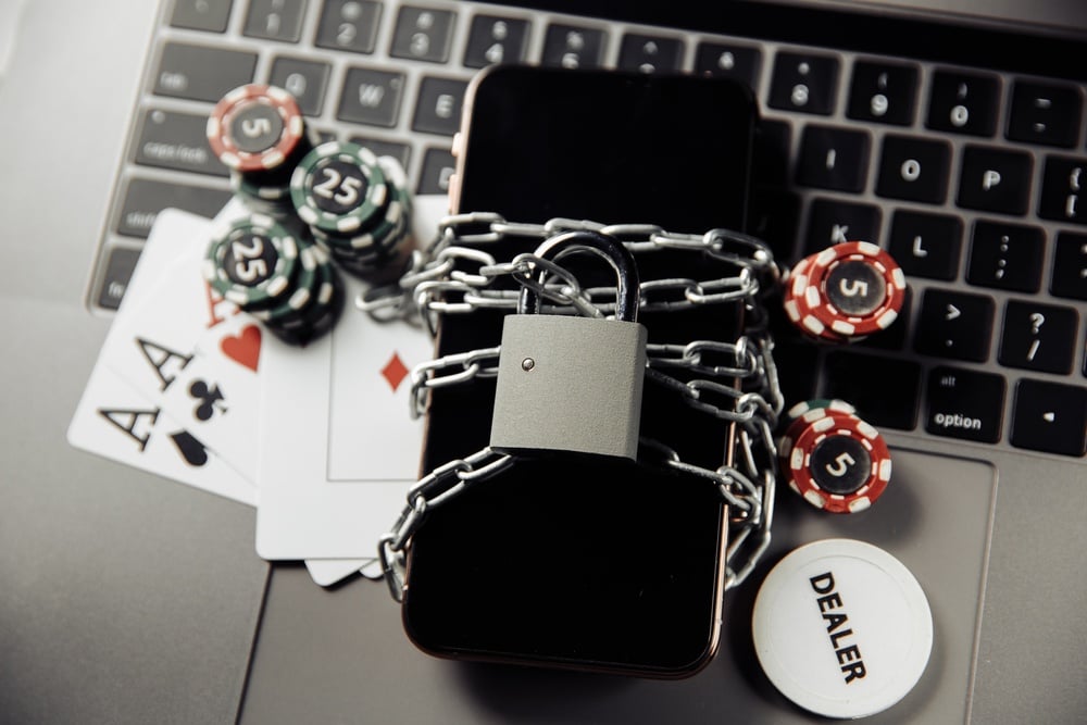 Shutterstock image depicting a digital lock and security symbols representing online gaming security and challenges with AI infiltration.