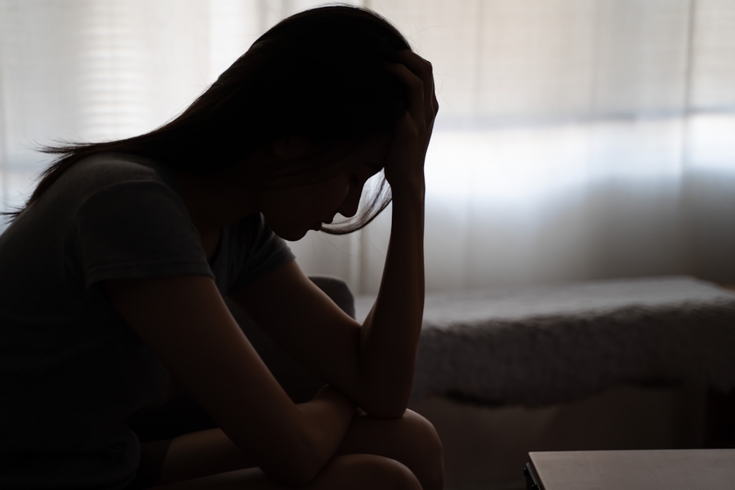 Woman sitting with hands on head