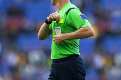 Soccer referee to point out a yellow card to a player during a match