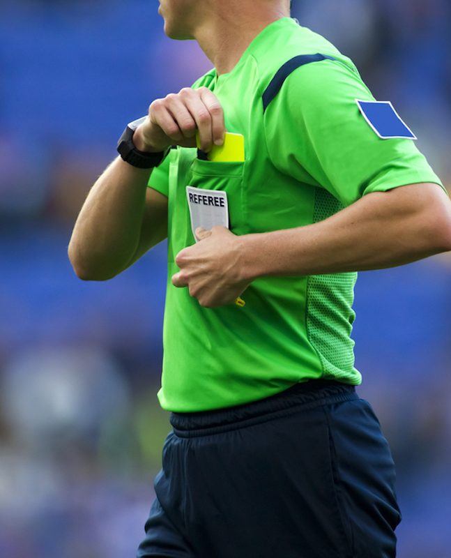 Soccer referee to point out a yellow card to a player during a match