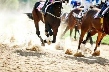 Horses running on a sand track