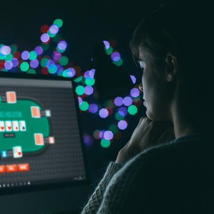 Woman playing online poker late at night