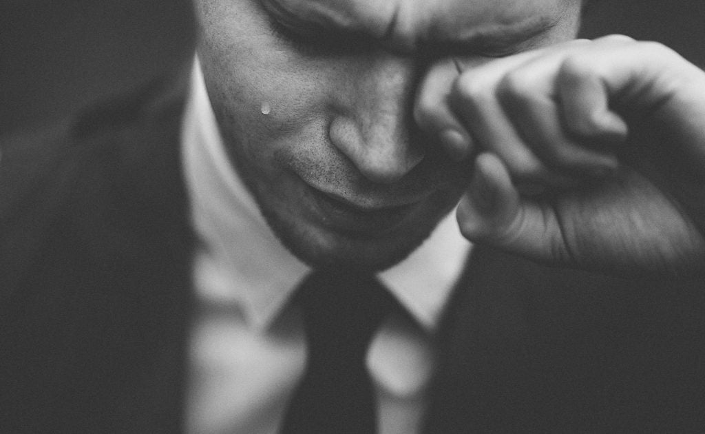 man crying in black and white photo