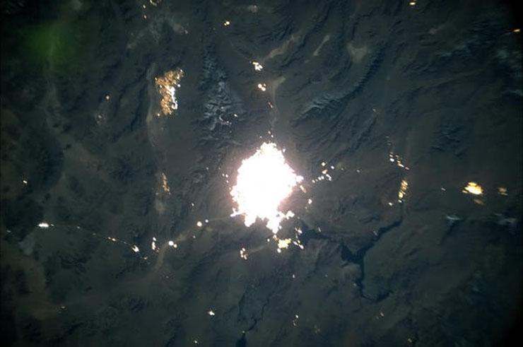 photo from space showing las vegas glowing surrounded by darkness