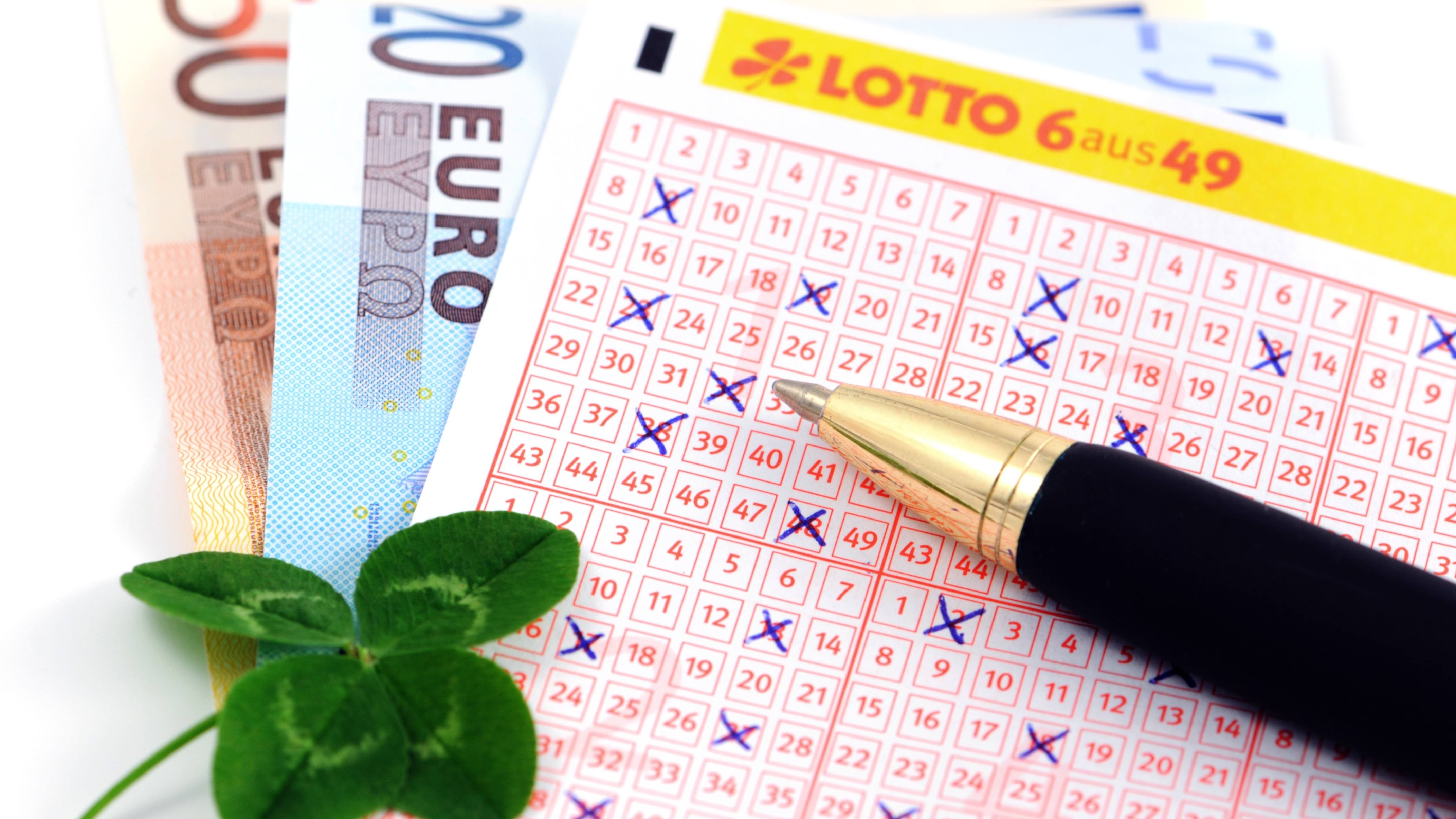 Lottoschein mit Glückskleeblatt und Euroscheinen