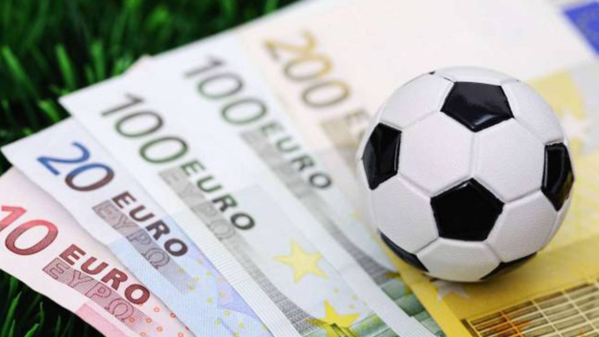 Ein Fußball liegt auf Euroscheinen als Sinnbild für Sportwetten