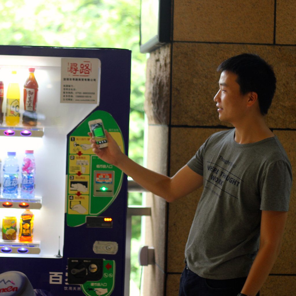 Getränkeautomat, Mann mit Smartphone