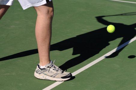 Tennispielerbeine auf dem Platz