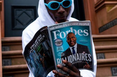 Mann liest im Forbes-Magazin