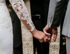 händchenhaltendes Hochzeitspaar von hinten