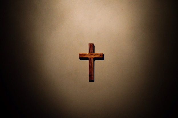 Christliches Holzkreuz in Lichtkranz