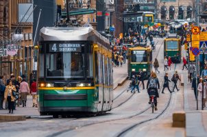 Strasse in Helsinki mit Fußgängern und Tram