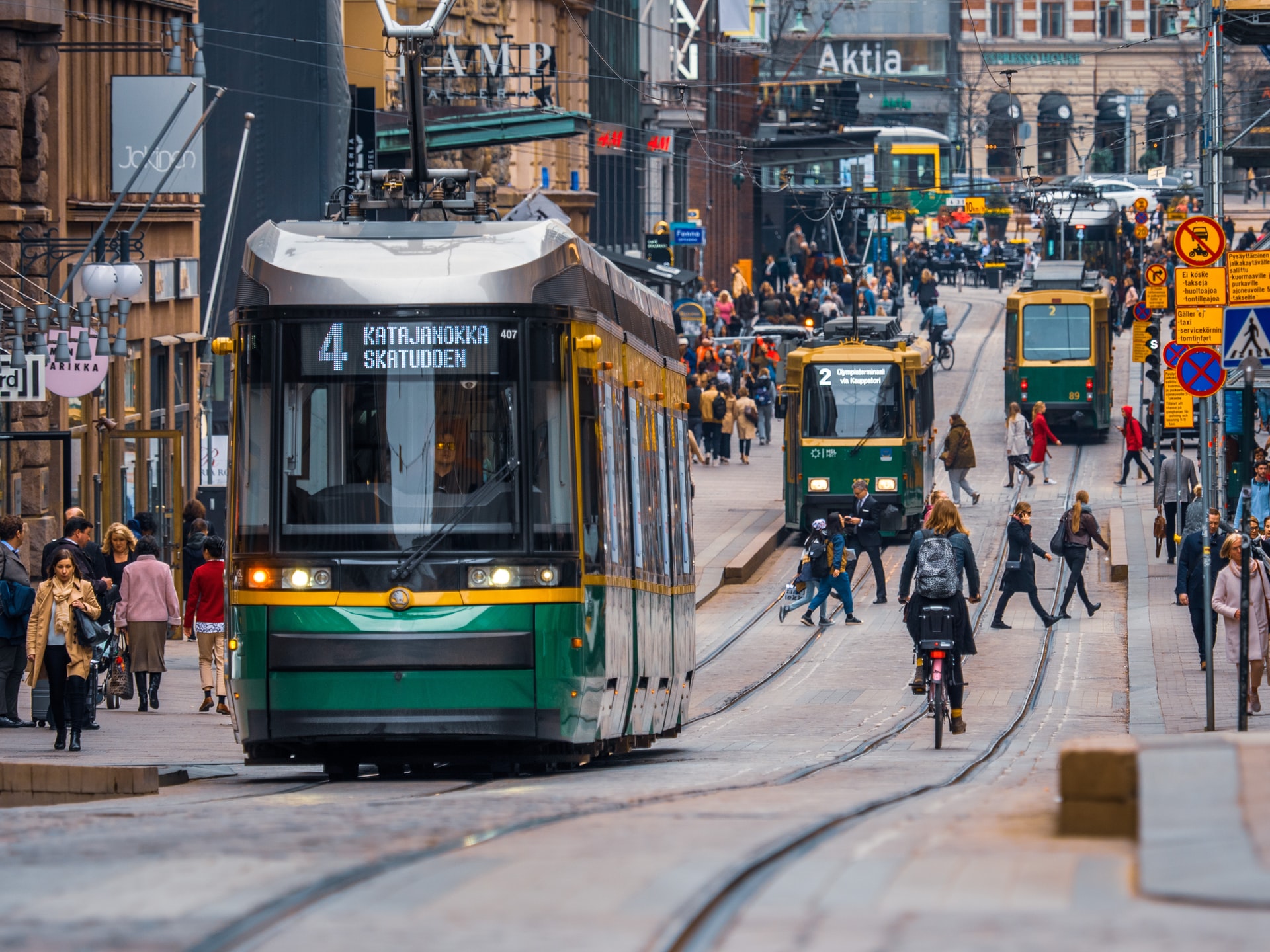 Strasse in Helsinki mit Fußgängern und Tram