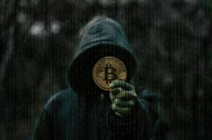 Mann mit Kapuze und Bitcoin