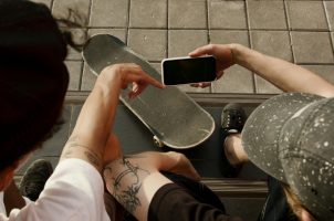 Skaterboarder mit Smartphone