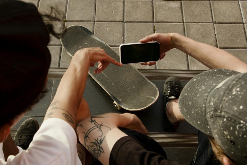 Skaterboarder mit Smartphone