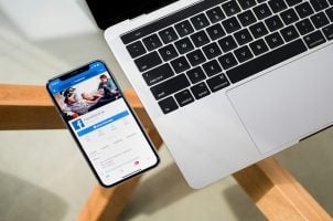Handy mit Facebook-App neben Notebook