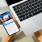 Handy mit Facebook-App neben Notebook