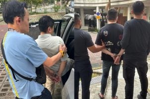 Polizisten mit verhafteten Männern